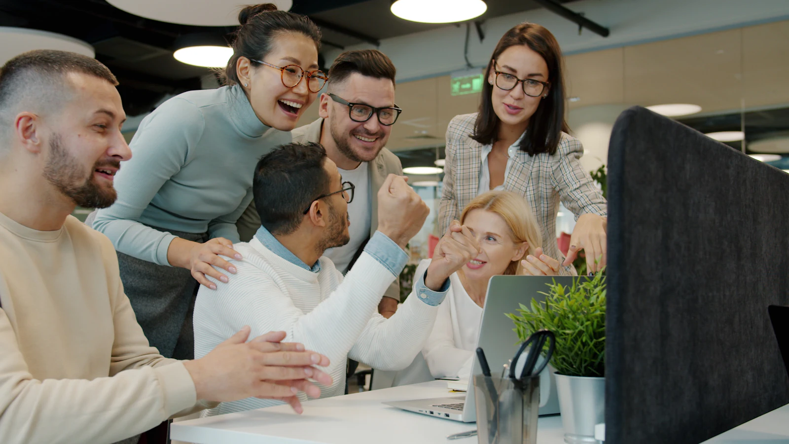 Een team viert samen een succes aan het bureau